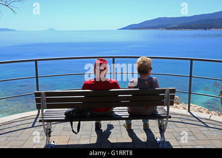 Rentner sitzen auf Bank mit Blick auf Kvarner Bucht, Istrien, Kroatien. Stockfoto