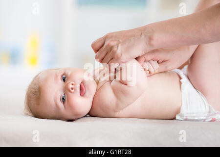 Mutter ihr Babymädchen massieren Stockfoto