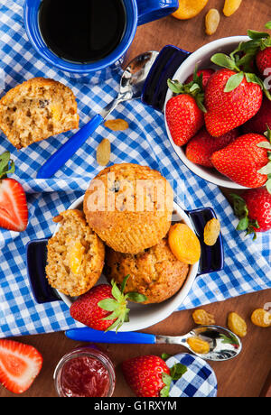 Frühstück mit hausgemachten Karotten Muffins, Marmelade, Kaffee und frischen Erdbeeren Stockfoto