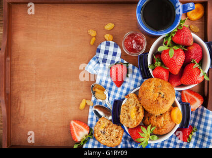 Frühstück mit hausgemachten Karotten Muffins, Marmelade, Kaffee und frischen Erdbeeren Stockfoto