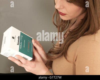 Porträt einer Frau mit einer Schachtel Rezept Ventolin Inhaler Kapseln Lesen der Informationen oder Anweisungen Stockfoto