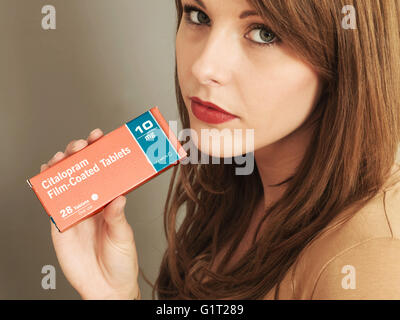 Porträt einer Frau mit einem Paket von Citalopram 10mg Tabletten bis in die Kamera schaut Stockfoto