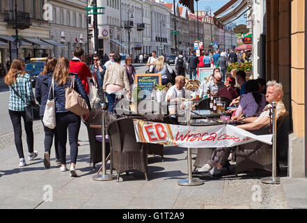 Menschen sitzen vor Restaurant auf Nowy Swiat-Straße in Warschau, Polen Stockfoto