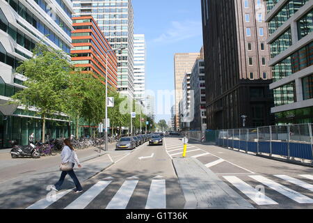 Frau über die Straße, Amsterdam Finanzviertel Zuidas (Süd-Achse), Amsterdam, Niederlande Stockfoto