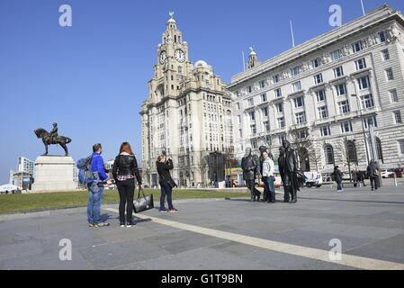 Fans der Beatles posieren für Fotos mit Statue am Pierhead, Liverpool, UK Stockfoto