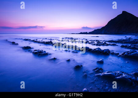 Das felsige Ufer an Spekes Mühle Mündung an der Küste von North Devon in der Abenddämmerung in der Nähe von Hartland, England. Stockfoto