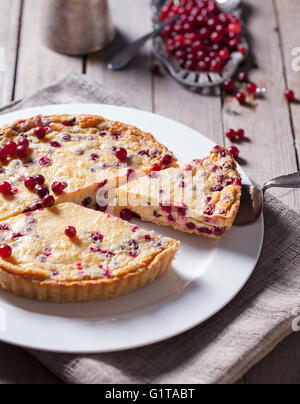 Weiße Schokoladen-Käsekuchen-Torte mit Preiselbeeren auf einem weißen Teller Stockfoto