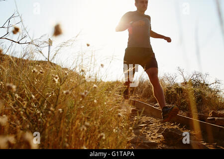 Mann läuft auf sonnigen trail Stockfoto