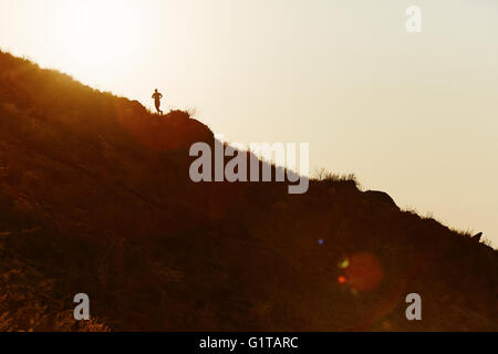 Silhouette der Läufer aufsteigender Hügel bei Sonnenuntergang Stockfoto