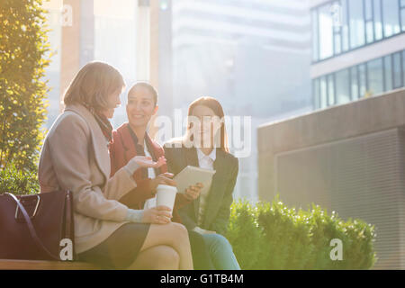 Lächelnd Geschäftsfrauen mit digital-Tablette Kaffeetrinken im freien Stockfoto