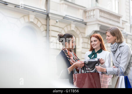 Frauen mit Einkaufstaschen betrachten Schal Stockfoto