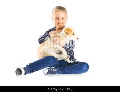 kleine Mädchen und Border Collie Welpen. Kind mit junger Hund isoliert auf weißem Hintergrund. Stockfoto