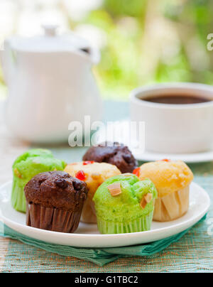 Auswahl an Muffins Vanille, Schokolade, Pandan auf einem weißen Teller Stockfoto