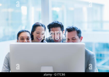 Lachende Geschäftsleute arbeiten am Computer im Büro Stockfoto