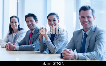 Porträt des Lächelns Geschäftsleute sitzen in einer Reihe im Konferenzraum Stockfoto