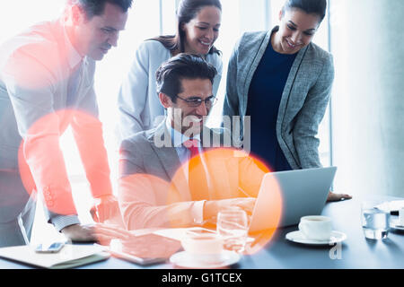 Lächelnde Geschäftsleute arbeiten am Laptop im Zimmer Tagung Stockfoto