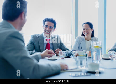 Lächelnde Geschäftsleute sprechen im Konferenzraum Stockfoto