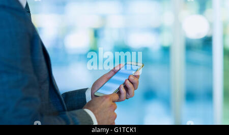 Geschäftsmann mit Handy im Büro Stockfoto