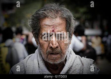 Ein grauhaariger und unrasierter Mann geht durch die Straßen außerhalb der Kapaleeshwarar Tempel, Mylapore, Chennai, Tamil Nadu, Indien Stockfoto