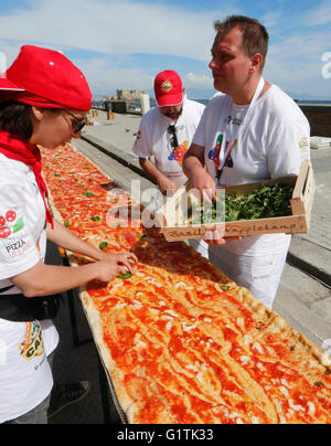 Neapel, Italien. 18. Mai 2016. Pizza-Hersteller versuchen, den Weltrekord für die längste Pizza der Welt auf die Küste von Neapel 18 zu brechen Mai 2016 zu machen, die 1,8 Kilometer von gebackene Holzofen-Pizza für die dienten: 2.000 kg Mehl, 1600 kg Tomaten, Mozzarella, 200 Liter Öl und 1500 Liter Wasser 2.000 kg. Bildnachweis: Agnfoto/Alamy Live-Nachrichten Stockfoto