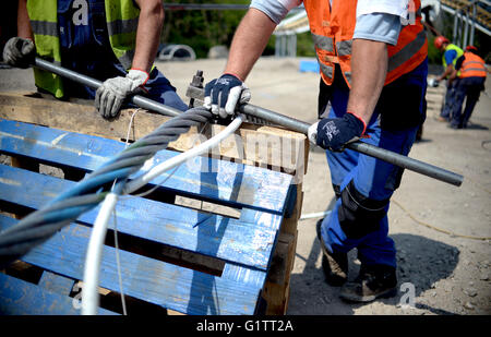 Arbeitnehmer splice die Steuerleitung für die Seilbahn auf der Baustelle für die internationale Garten zeigen (IGA) in Berlin, Deutschland, 18. Mai 2916. Ab Frühjahr 2017, fahren Gondeln auf der 1,5 km lange Strecke in einer Höhe von 30 Metern. Foto: Britta Pedersen/dpa Stockfoto