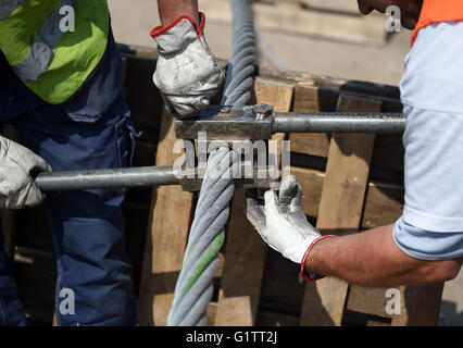 Arbeitnehmer splice die Steuerleitung für die Seilbahn auf der Baustelle für die internationale Garten zeigen (IGA) in Berlin, Deutschland, 18. Mai 2916. Ab Frühjahr 2017, fahren Gondeln auf der 1,5 km lange Strecke in einer Höhe von 30 Metern. Foto: Britta Pedersen/dpa Stockfoto