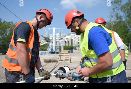 Arbeitnehmer splice die Steuerleitung für die Seilbahn auf der Baustelle für die internationale Garten zeigen (IGA) in Berlin, Deutschland, 18. Mai 2916. Ab Frühjahr 2017, fahren Gondeln auf der 1,5 km lange Strecke in einer Höhe von 30 Metern. Foto: Britta Pedersen/dpa Stockfoto