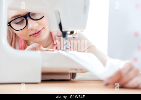 Charmante junge Näherin konzentriert bei der Arbeit mit Tuchgewebe Stockfoto