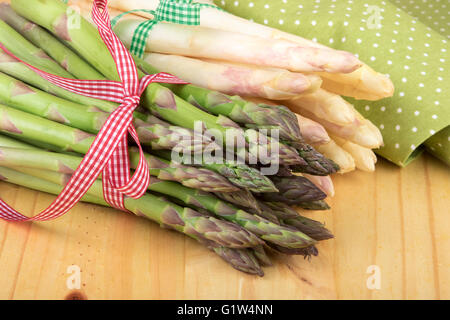Grünen und weißen Spargel auf Holztisch in Nahaufnahme. Veganes Essen, vegetarische und gesunde Koch-Konzept. Stockfoto
