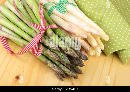 Bündel von grünem und weißem Spargel auf hellem Holz. Veganes Essen, vegetarische und gesunde Koch-Konzept. Stockfoto