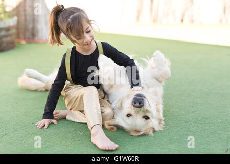 Kleines Mädchen mit ihrem Hund mit Zeichen der Zuneigung Stockfoto