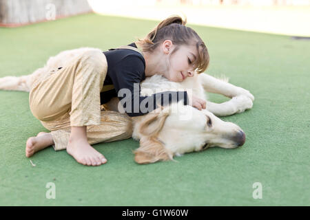 Kleines Mädchen mit ihrem Hund mit Zeichen der Zuneigung Stockfoto