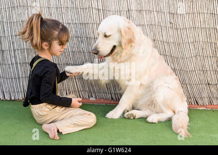 Kleines Mädchen mit ihrem Hund mit Zeichen der Zuneigung Stockfoto