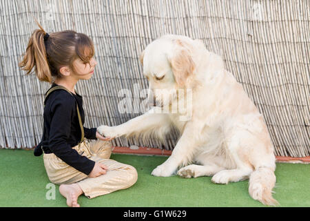 Kleines Mädchen mit ihrem Hund mit Zeichen der Zuneigung Stockfoto