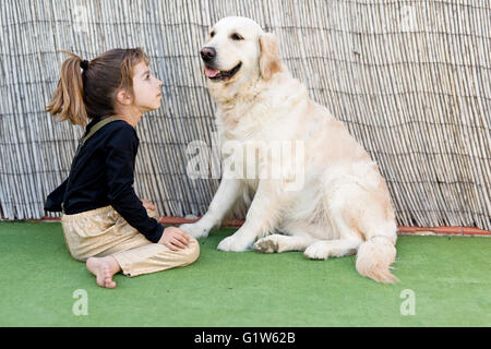 Kleines Mädchen mit ihrem Hund mit Zeichen der Zuneigung Stockfoto