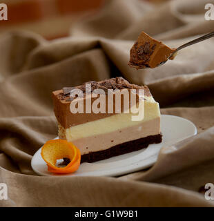 leckeres Stück geschichtete Kuchen auf weißen Teller mit einem kleinen Löffel Stockfoto