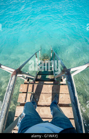 Alte Vintage Metall Holz Treppe zum türkisfarbenes Meer blau Wasser vom Strand entfernt. Schönen Sommertag. Schwimmbad mit Grunge Retro-Treppen an der Ozeanküste. Top POV Sicht erschossen Stockfoto