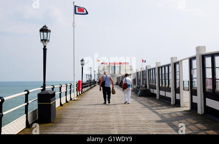 Worthing West Sussex UK View - Paare, die auf Worthing Pier mit Spielhalle im Hintergrund Stockfoto