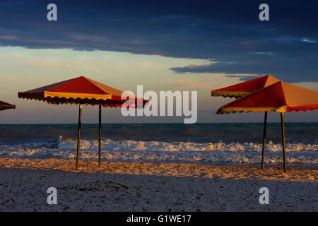 Leerer Strand mit Sonnenschirmen in schlecht, stürmischen Wetter Stockfoto