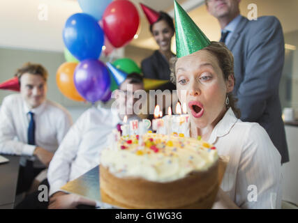 Kolleginnen und Kollegen gerade Geschäftsfrau Ausblasen Geburtstag Kuchen Kerzen Stockfoto