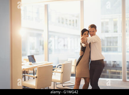 Unternehmer und Unternehmerin tanzen im Konferenzraum Stockfoto