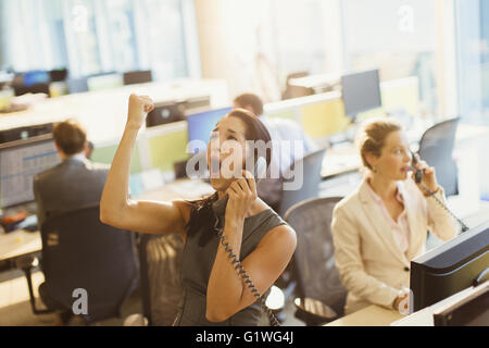 Üppige Frau am Telefon, die gute Nachricht im Büro feiern Stockfoto