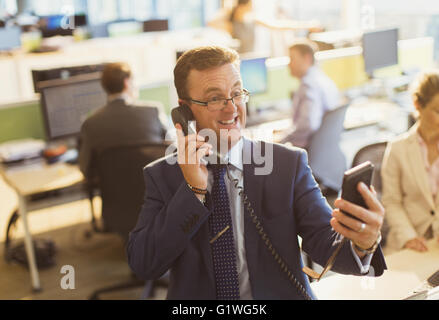 Spielerische Geschäftsmann Gespräch am Telefon und nehmen Selfie im Büro Stockfoto