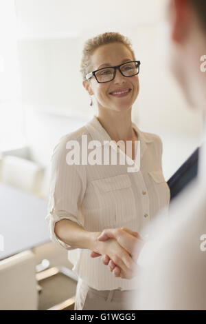 Geschäftsfrau Händeschütteln mit Geschäftsmann lächelnd Stockfoto