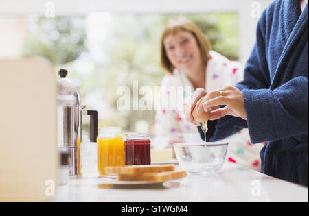 Frau Mann Riss Ei in Küche beobachten Stockfoto