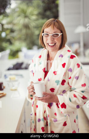 Porträt lächelnd Reife Frau Kaffeetrinken im Bademantel Stockfoto