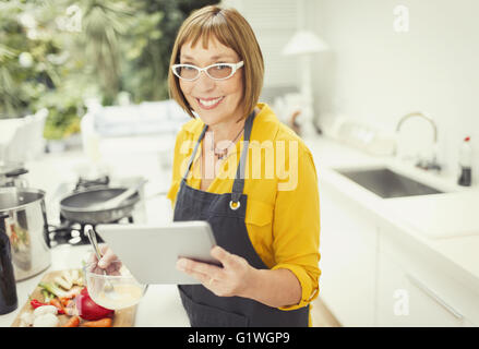 Porträt lächelnd Reife Frau mit digital-Tablette in Küche Stockfoto