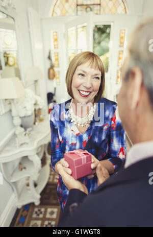 Reife Frau empfangende Geschenk Mann lächelnd Stockfoto
