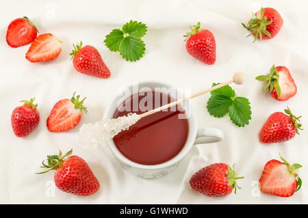 Frische Erdbeeren mit Erdbeersaft auf weißer Seide Stoff Stockfoto