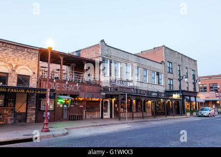 Straße im Stadtteil Fort Worth Stockyards bei Einbruch der Dunkelheit beleuchtet. Texas, USA Stockfoto